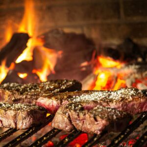 Succulent steaks grilling over hot coals and flames for a mouthwatering cookout.