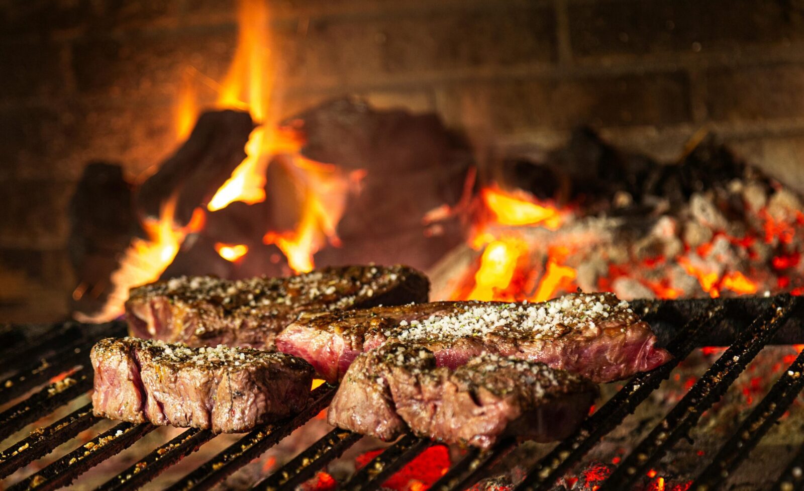 Succulent steaks grilling over hot coals and flames for a mouthwatering cookout.