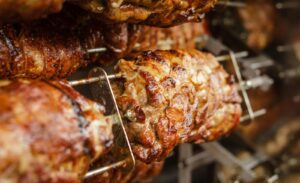 Close-up of juicy and perfectly grilled rotisserie pork, ideal for barbecue lovers.